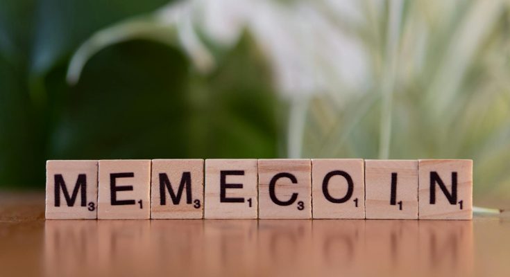 Wooden tiles spelling 'Memecoin' on a blurred background.